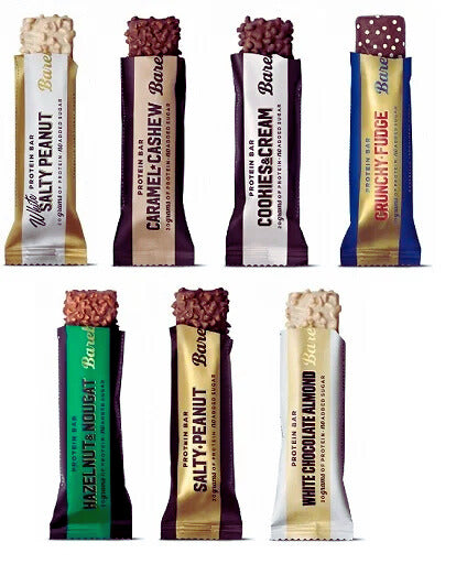 Ein Barebells Proteinriegel in Nahaufnahme, umgeben von natürlichen Zutaten wie Mandeln und Kakaobohnen. Der Riegel ist schokoladig und appetitlich, und das Protein-Logo ist gut sichtbar. Hintergrund ist schlicht, um den Riegel in den Mittelpunkt zu stellen